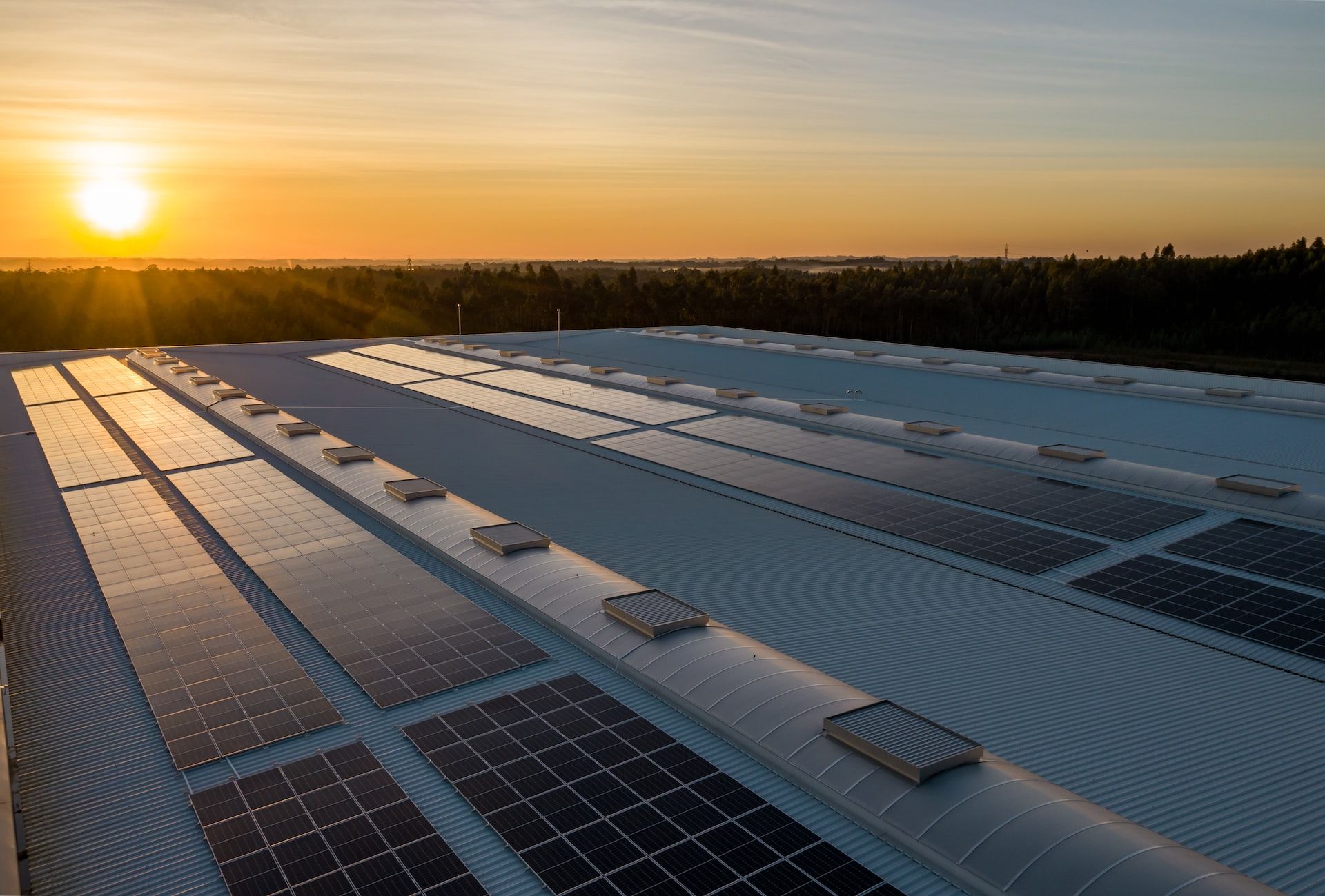 Rooftop solar panel array at sunrise on a large building